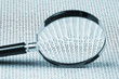 magnifying glass on a binary code