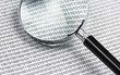 magnifying glass on a binary code