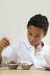 Boy pouring flour mixture on cupcakes
