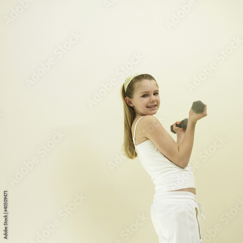 Foto: Little girl lifting dumbbell Little girl lifting dumbbell
