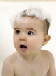 Baby girl with soap suds on her head