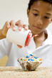 Boy decorating a small cake