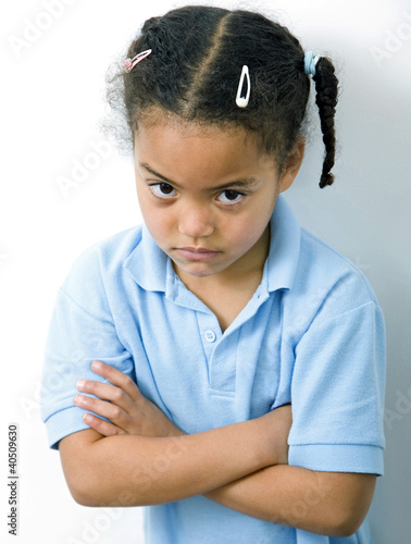Photo: Girl folding her arms while staring at the camera Girl folding her arms while staring at the camera