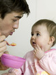 Father feeding baby girl