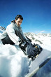 Male snowboarder strapping board onto feet