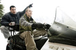 Two men riding on snowmobile