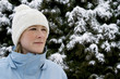 Woman wearing knit hat and winter clothing standing outdoor