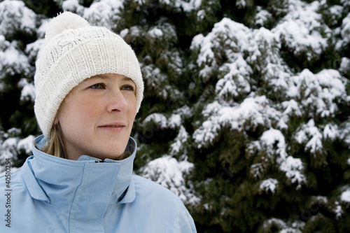 Photo: Woman wearing knit hat and winter clothing standing outdoor Woman wearing knit hat and winter clothing standing outdoor