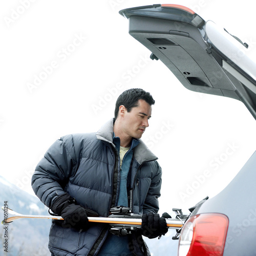 Photo: Man keeping skis in the jeep Man keeping skis in the jeep