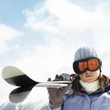 Woman in ski goggles holding skis