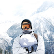 Man in warm clothing hugging snowboard
