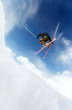 Man doing a mid air ski jump off a mountain 