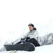 Male snowboarder sitting alone