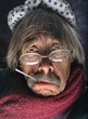 Mature man wrapped in towel with thermometer in mouth and ice pack on his head