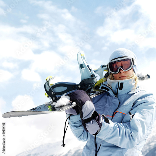Photo: Woman in ski goggles holding snowboard Woman in ski goggles holding snowboard