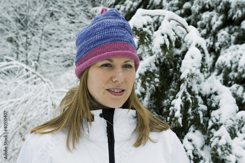 Photo: Woman wearing knit hat and winter clothing standing outdoor Woman wearing knit hat and winter clothing standing outdoor