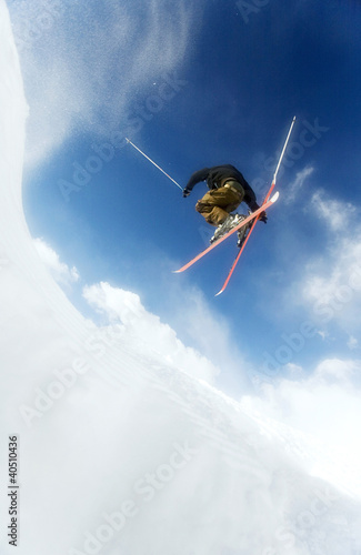 Photo: Man doing a mid air ski jump off a mountain Man doing a mid air ski jump off a mountain