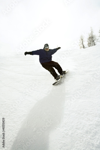 Photo: Snowboarder riding downhill Snowboarder riding downhill