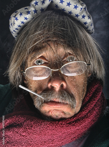 Photo: Mature man wrapped in towel with thermometer in mouth and ice pack on his head Mature man wrapped in towel with thermometer in mouth and ice pack on his head