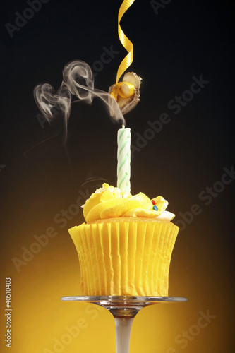 Photo: A cupcake with blown out candle and a frog hanging from a streamer A cupcake with blown out candle and a frog hanging from a streamer