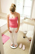 Foto: Girl standing on weight scale Girl standing on weight scale
