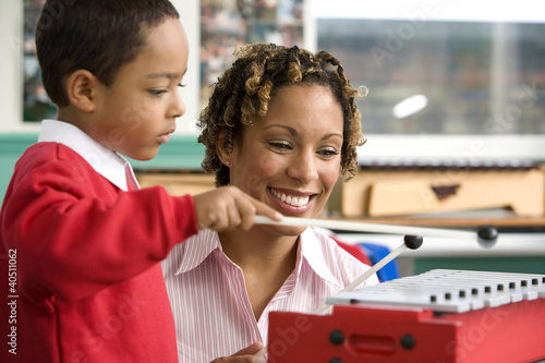 Photo: Woman teaching boy to play xylophone Woman teaching boy to play xylophone