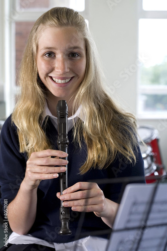 Photo: Girl playing recorder in music room Girl playing recorder in music room