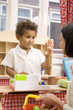 Foto: Boy gesturing while playing with toys, woman carrying basket Boy gesturing while playing with toys, woman carrying basket