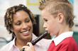 Woman teaching boy to play recorder