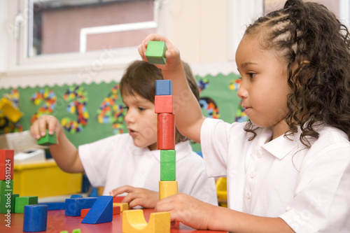 Photo: Boy and girl stacking up wooden blocks Boy and girl stacking up wooden blocks