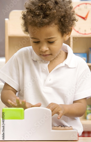 Photo: Boy playing with toy cash register Boy playing with toy cash register