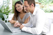 Man and woman using credit card to purchase product online