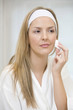 Woman cleaning her face with cotton wool