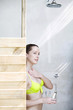 Woman applying bath liquid on body while taking a shower