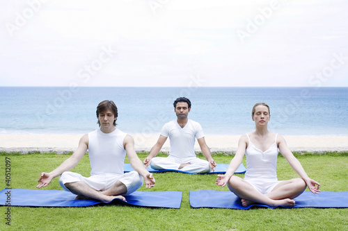 Photo: Men and woman pratising yoga Men and woman pratising yoga