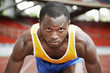 Foto: Man in starting position on running track Man in starting position on running track