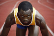 Foto: Man in starting position on running track Man in starting position on running track