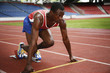 Foto: Man in starting position on running track Man in starting position on running track