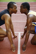 Foto: Men in starting position on running track, face to face Men in starting position on running track, face to face