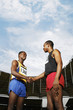 Men shaking hands on running track