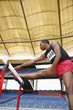 Man resting his leg on a hurdle while stretching