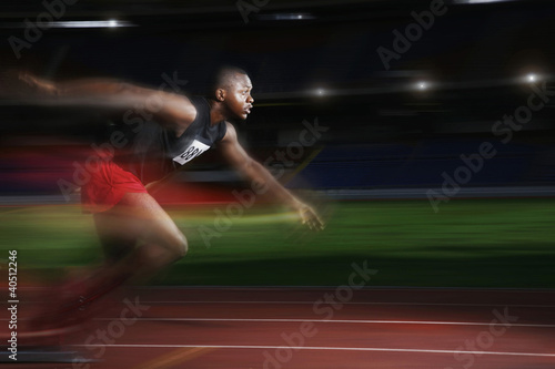 Photo: Man running at a fast speed on the running track Man running at a fast speed on the running track