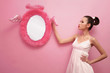 Woman posing beside wall mirror