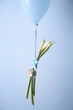 A gift and three lilies tied to a balloon