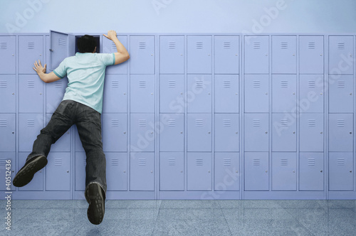 Photo: Man peeking into a locker Man peeking into a locker