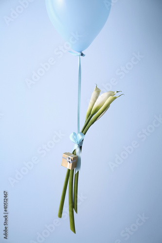 Photo: A gift and three lilies tied to a balloon A gift and three lilies tied to a balloon
