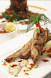 Fried salmon fillet with mashed potato and another main course in the background
