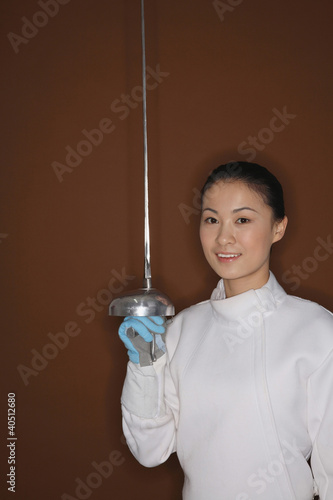 Foto: Woman with fencing foil posing for the camera Woman with fencing foil posing for the camera
