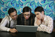 Three men looking at laptop