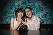 Man and woman laughing while listening to phone conversation